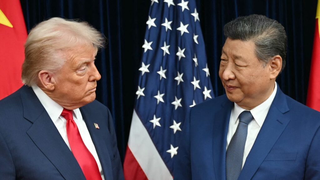 US President Donald Trump (L) and China's President Xi Jinping greet each other as they arrive for talks at the Gimhae Air Base, located next to the Gimhae International Airport in Busan on October 30, 2025.