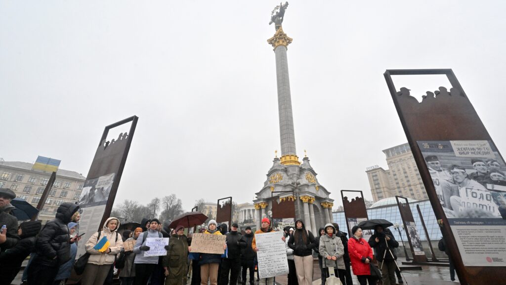 Protesters hold placards during an anti-corruption rally at the Independence Square in Kyiv, claiming for Presidential Office Chief Andriy Yermak's resignation, on November 22, 2025, amid Russian invasion in Ukraine. (Photo by Sergei SUPINSKY / AFP)