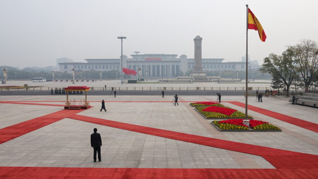 The national flag of Spain flutters in the wind atop a pole with a general view of Tiananmen Square seen in the background before a welcoming ceremony by China’s President Xi Jinping for Spain's King Felipe VI at the Great Hall of the People in Beijing on November 12, 2025.