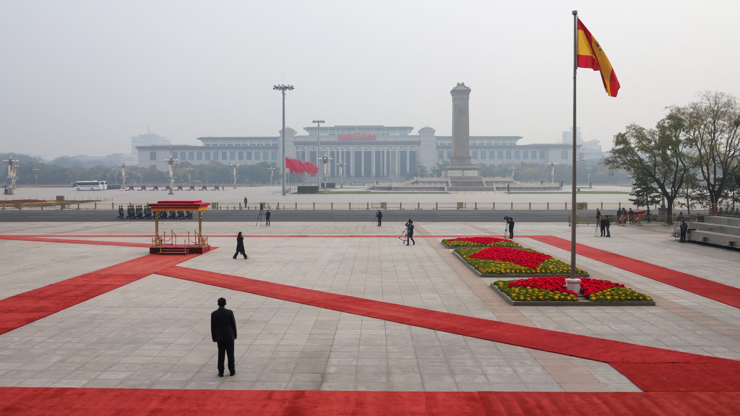 The national flag of Spain flutters in the wind atop a pole with a general view of Tiananmen Square seen in the background before a welcoming ceremony by China’s President Xi Jinping for Spain's King Felipe VI at the Great Hall of the People in Beijing on November 12, 2025.