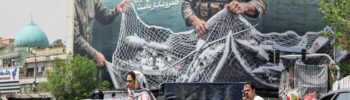 Iranian walks past a giant billboard reading 'The Strait of Hormuz remains closed' at the Revolution Square in Tehran on April 22, 2026, amid a ceasefire in the region.