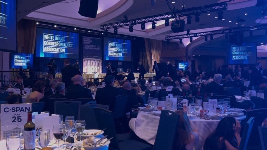 A screen grab taken from a video filmed by an AFP reporter shows armed agents moving to the stage after loud bangs were heard during the White House Correspondents' dinner at the Washington Hilton in Washington, DC, on April 25, 2026.