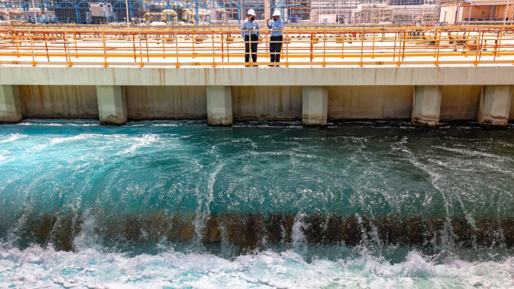 In this picture taken on March 30, 2023, Mohamed Ali al-Qahtani (L), Phase General Manager at the Ras al-Khair water desalination plant, owned by the Saudi government's Saline Water Conversion Corporation, speaks with an employee at the facility in Ras al-Khair along the Gulf coast in eastern Saudi Arabia. (Photo by Fayez Nureldine / AFP)