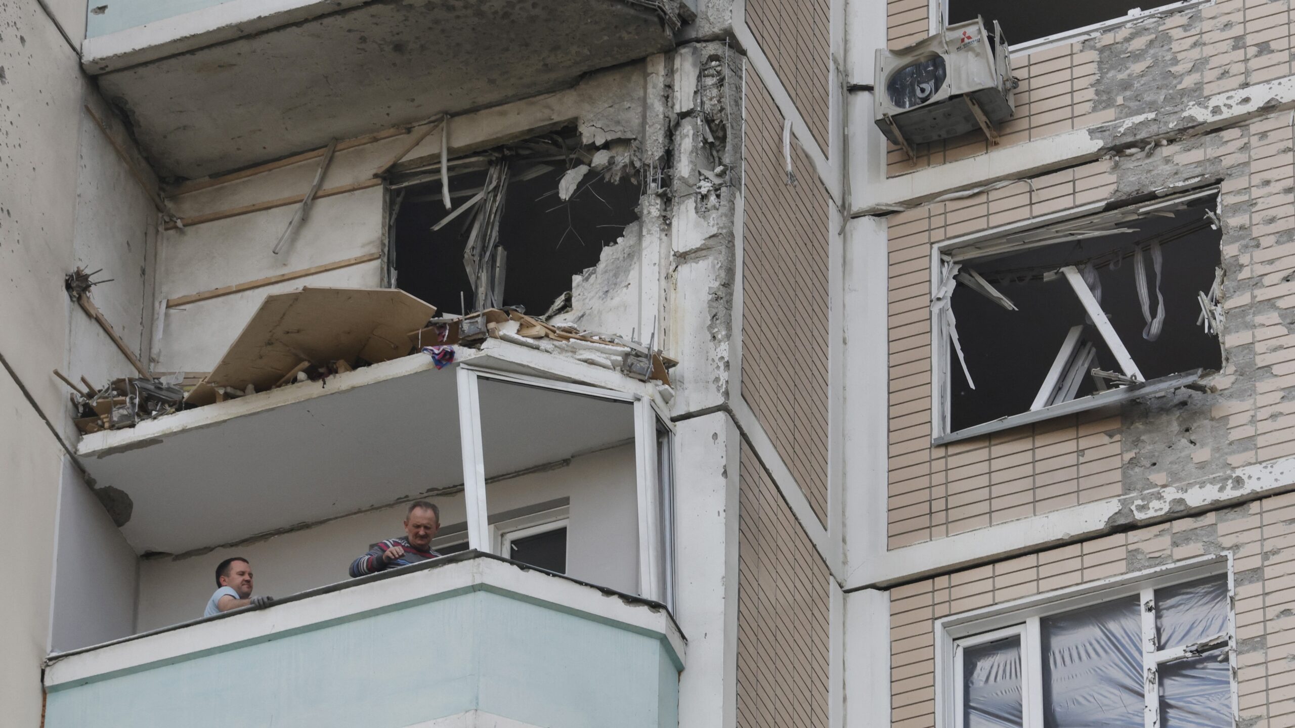 Local residents inspect a damaged balcony in a residential building following an air attack in Krasnogorsk, Moscow region on May 17, 2026, amid the ongoing Russian-Ukrainian conflict.